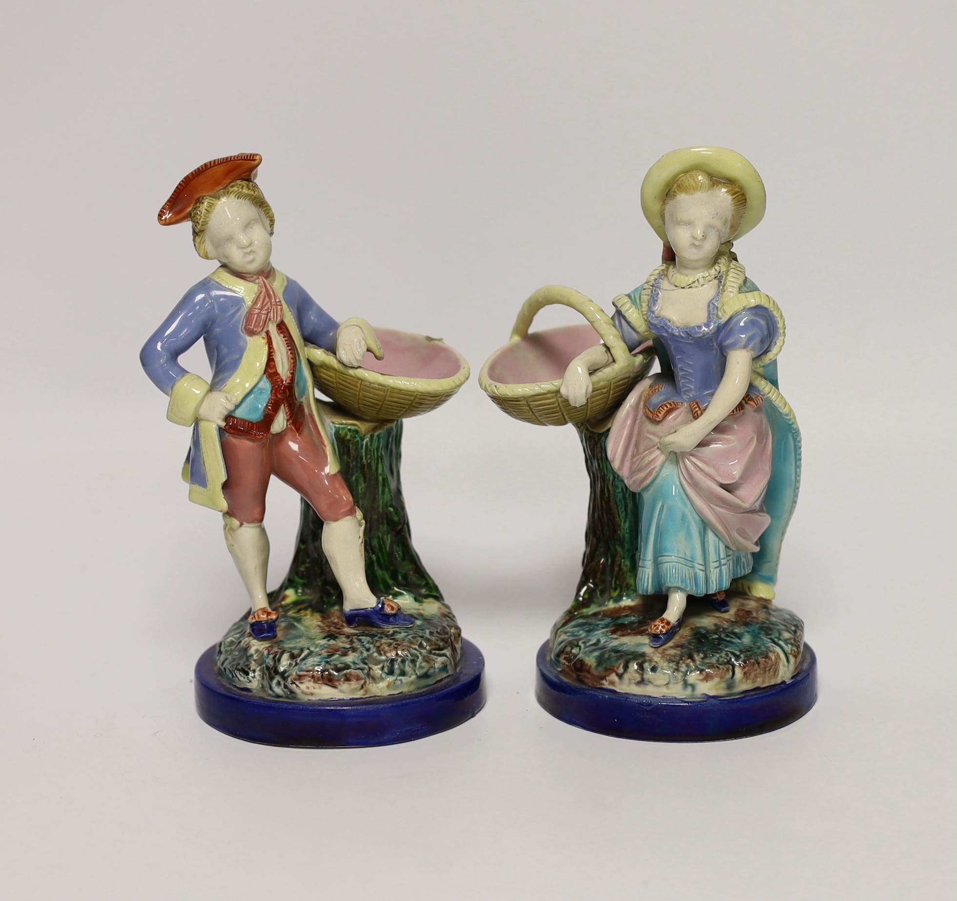 A pair of 19th century Worcester majolica figures holding baskets, largest 17cm high